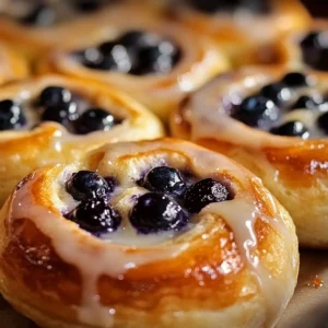 Lemon Blueberry Sweet Rolls topped with icing and fresh blueberries
