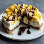 No bake banana split cheesecake topped with whipped cream and cherries