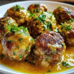 Plate of Greek meatballs in lemon sauce garnished with herbs