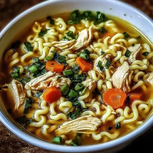 Bowl of Ginger Garlic Chicken Noodle Soup garnished with fresh herbs.