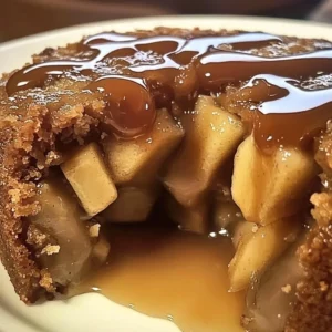 Sliced Apple Date Chai Pudding Cake topped with warm caramel sauce