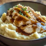 Delicious chicken mashed potato bowls with gravy and herbs served in a bowl