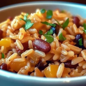 A bowl of irresistible Mediterranean Rice and Beans garnished with herbs.